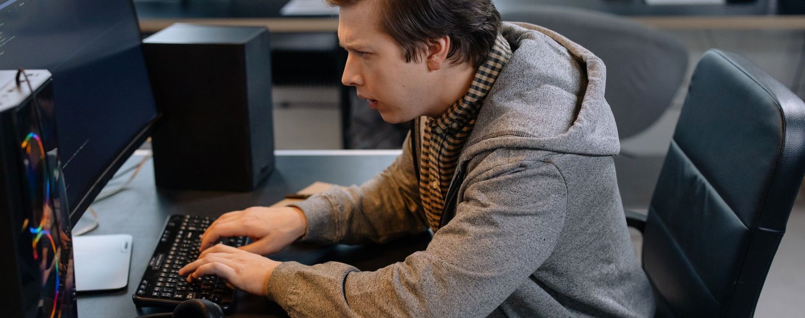Desarrollador trabajando frente a varios monitores en un despacho